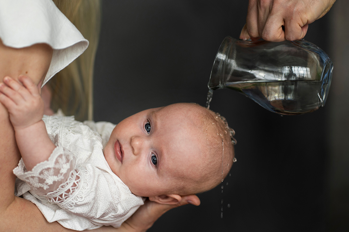 bambina mentre viene battezzata con l'acqua