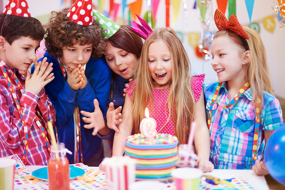 Bambina che soffia la candelina della torta per il suo compleanno