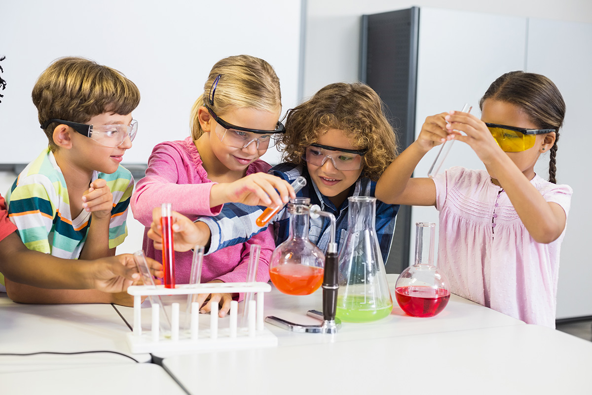 bambini che giocano con un kit di esperimenti scientifici