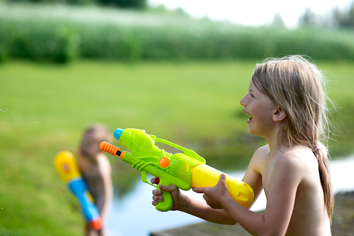 Una bambina che gioca con una pistola ad acqua