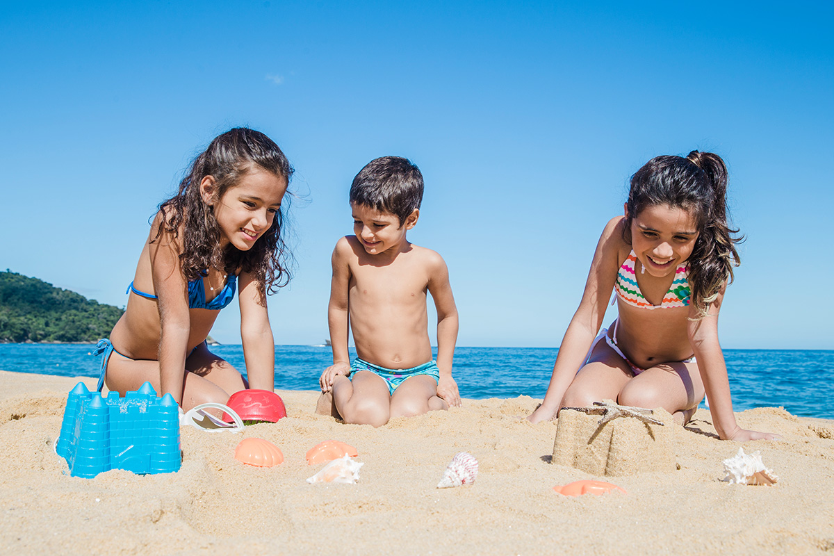 Bambini che giocano al mare con la sabbia