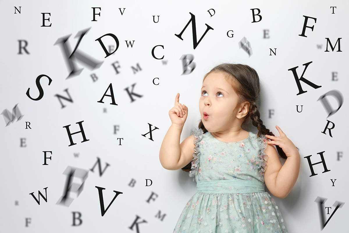 bambina che indica delle lettere dell'alfabeto astratte