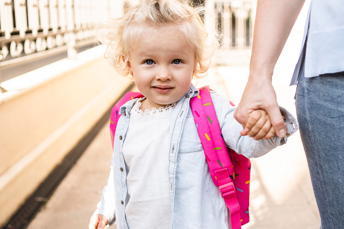 Bambina al suo primo giorno di asilo accompagnata dalla mamma