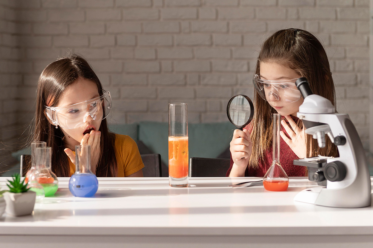 Bambine che giocano con un kit di scienze