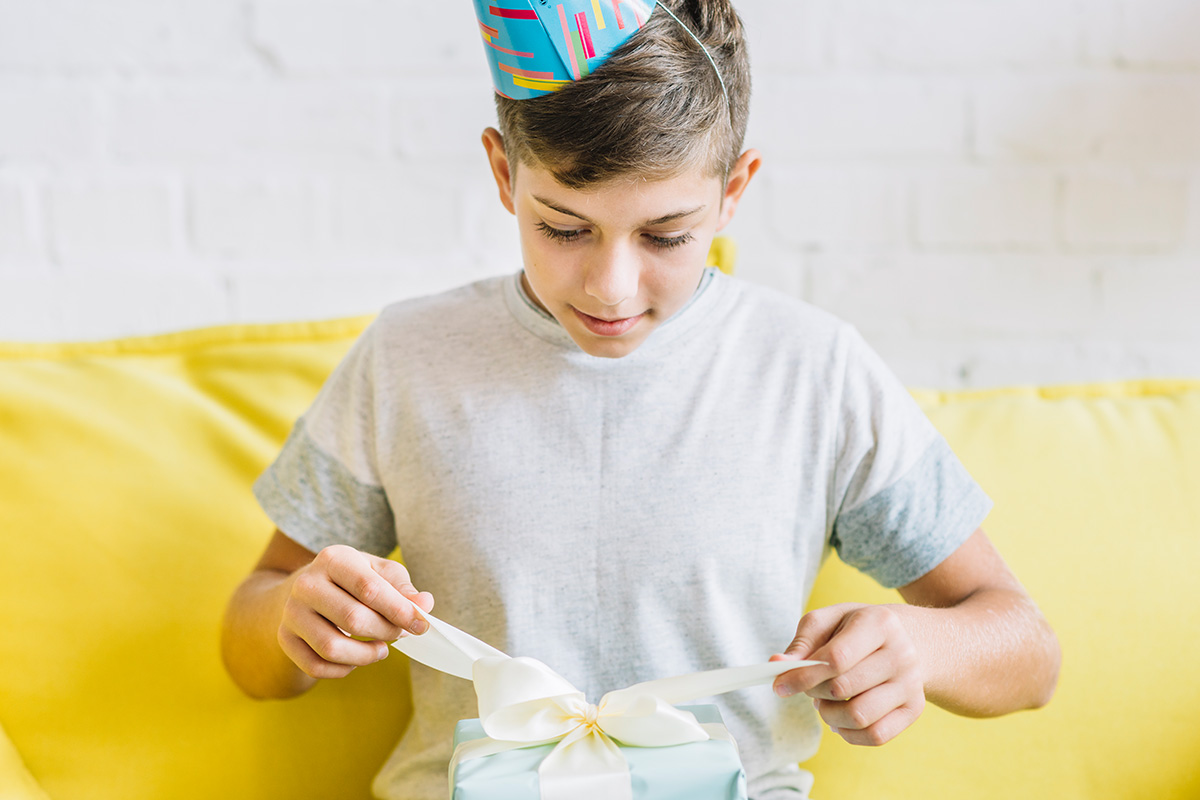 bambino di 10 anni che scarta un regalo